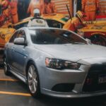 Luxury Cars - A modern silver car parked in a dynamic garage w #10182855