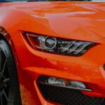 Luxury Cars - Dynamic close-up shot of a shiny orange sports c #12522971