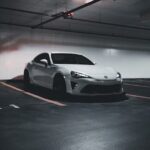 Luxury Cars - A sleek white sports car parked in a dimly lit u #17245056