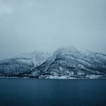 Mountain Landscapes - A serene view of snowy mountains and a lake in L #20219260