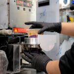 Food Aesthetics - Close-up of a beverage sealing machine sealing a #35815274